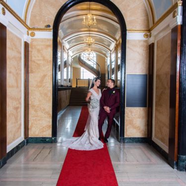 Bride and groom in decorative hallway in MI