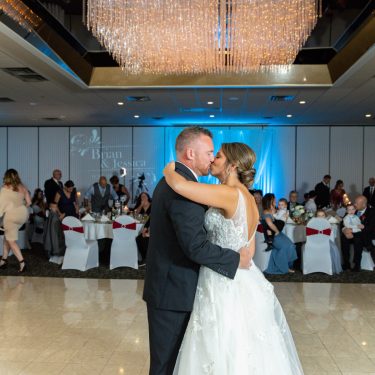 Bride and groom kissing on dance floor at wedding