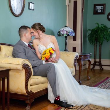 Bride and groom sitting on vintage couch