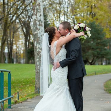 Bride and groom kissing in a park