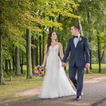 Bride and groom walking in forest