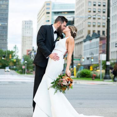 Bride and groom kissing in street in MI