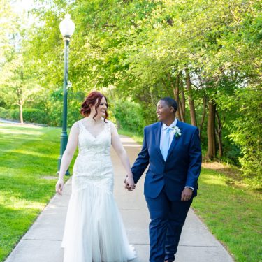 Married couple holding hands walking in a park