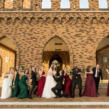 Bridal party in front of brick reception hall