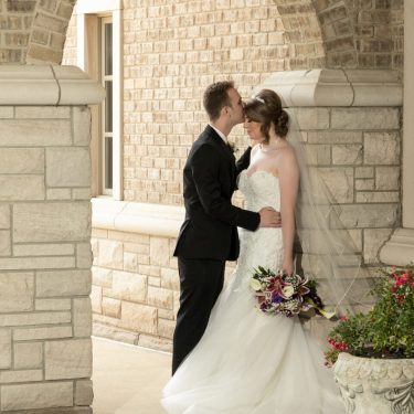 Bride and groom in stone courtyard